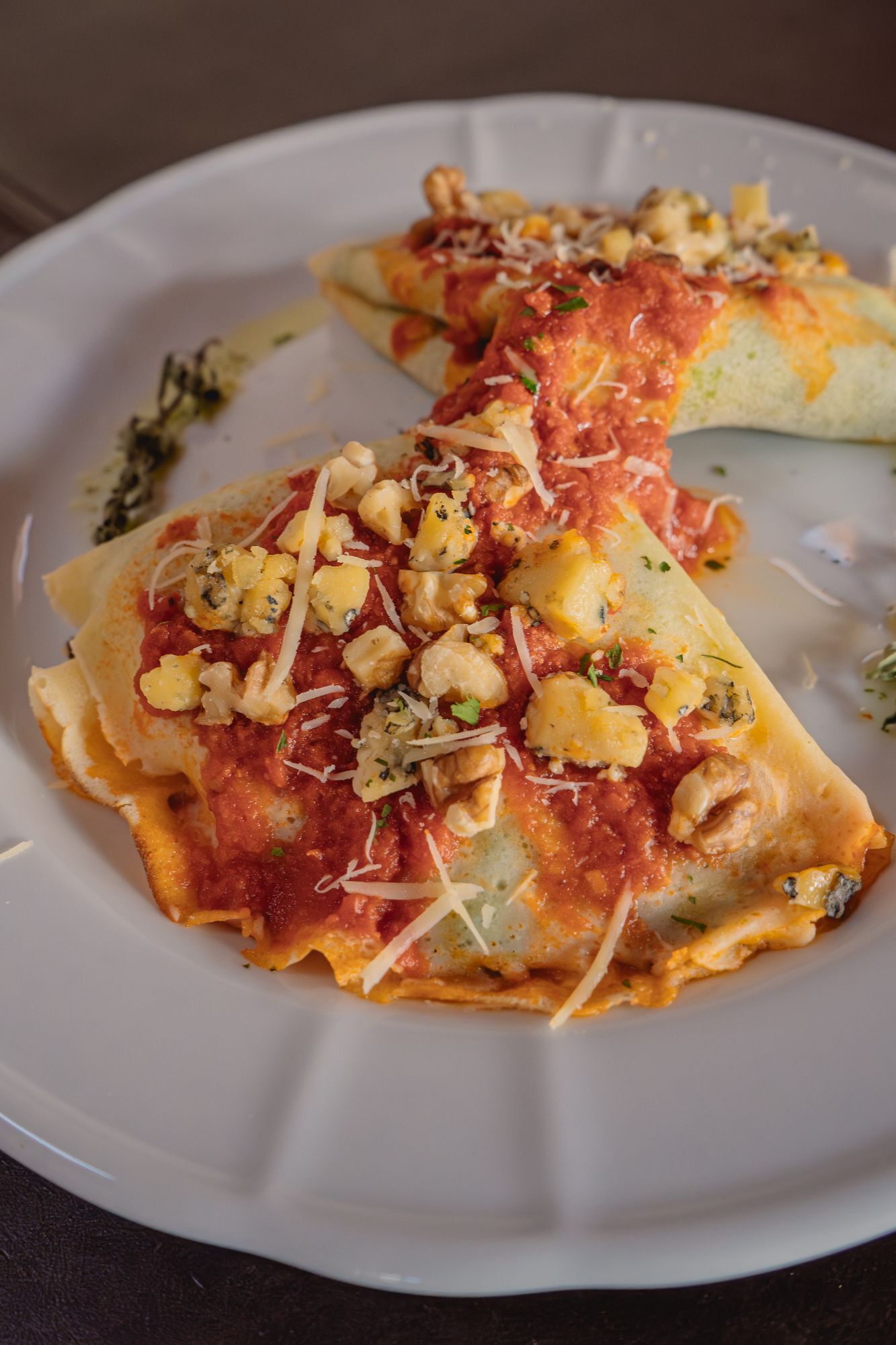 Crepes de espinaca y ricota con queso azul, nueces y salsa fileto