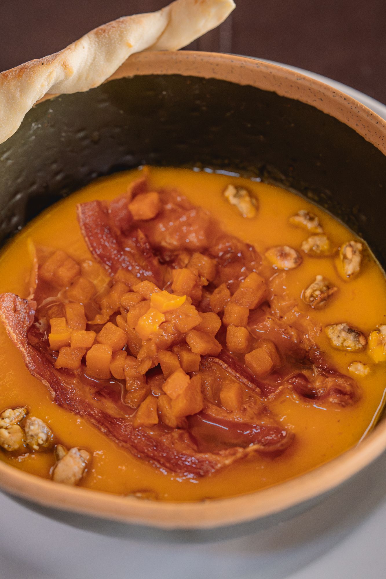 Crema de calabaza con praline de semillas de calabaza y panceta crocante