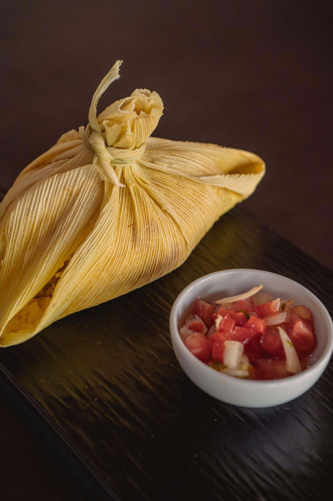 Humita gratinada, acompañada con albahaca y ensaladita criolla con maíz